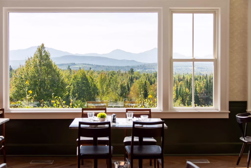 Restaurant table with panoramic White Mountains views framed by large windows in a scenic New Hampshire hotel dining space