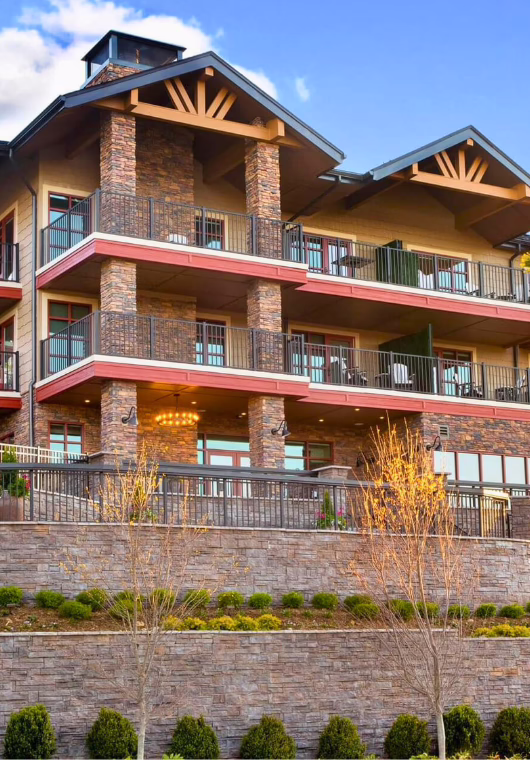 The Embers Hotel building in Blowing Rock, North Carolina, with warm lodge-style design, stacked stone details, and rows of balcony accommodations